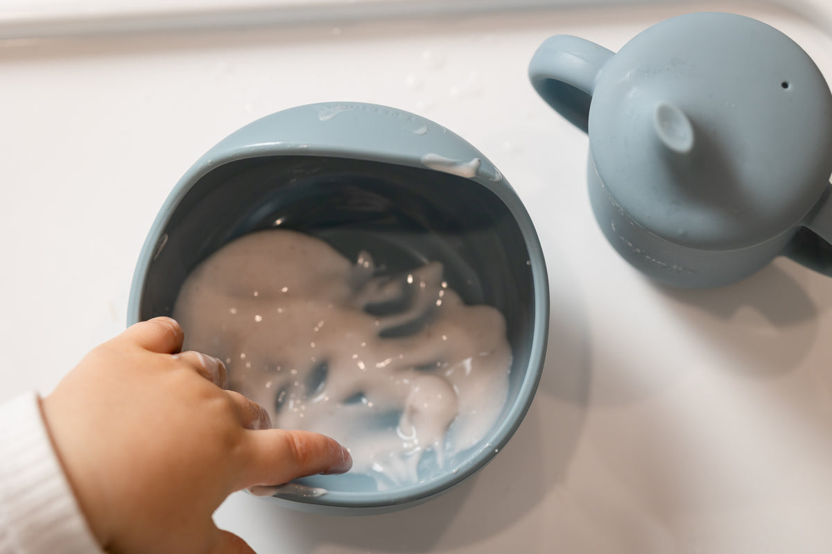 Light blue suction bowl on a tray with child holding the bowl rim