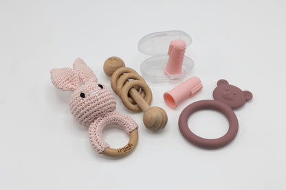 Pink teething essentials set with bunny teether, ring grip, and teether accessory