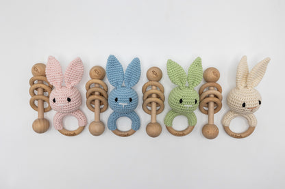 Mixed set of crochet bunny baby rattles with wooden ring teether in pastel tones.