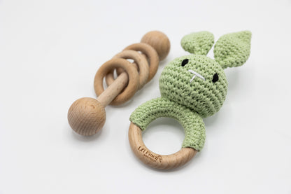 Green crochet bunny baby rattle with wooden ring handle and teething circle.