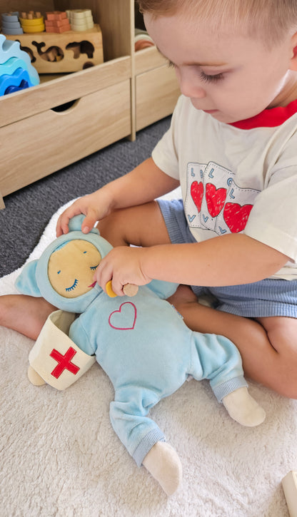 Child playing with plush doctor bunny doll holding red-cross medical patch