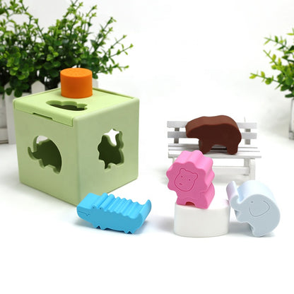 Light green shape sorter cube with top orange knob and five animal pieces