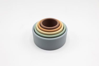 Nested stacking cups viewed from above in blue-gray, green, beige, and brown