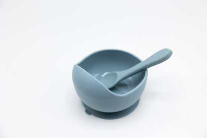 Blue suction bowl with spoon, empty bowl interior visible