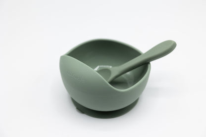 Green suction bowl with spoon, bowl interior and rim visible