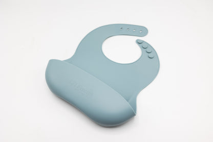 Dusty blue silicone bucket bib with droplet pattern and front pocket