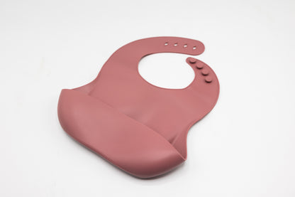 Powder rose silicone bucket bib with round neck opening and snap details
