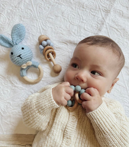 Light blue crochet bunny baby rattle with wooden ring beads and teething ring.