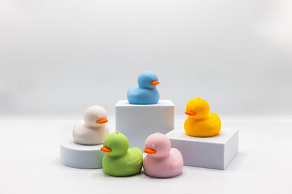 5 squeeze duck bath toys on blocks: blue, yellow, green, pink, white