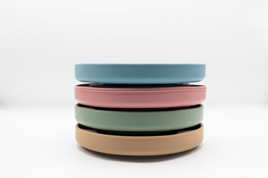Stack of pastel divider plates with suction base in blue, rose, sage, and latte colors.