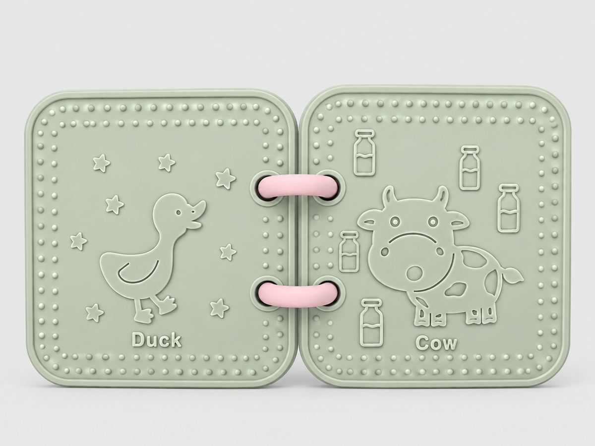 A silicone bath book in sage green , featuring embossed animal designs of a duck and a cow on a light gray background.