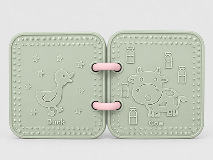 A silicone bath book in sage green , featuring embossed animal designs of a duck and a cow on a light gray background.