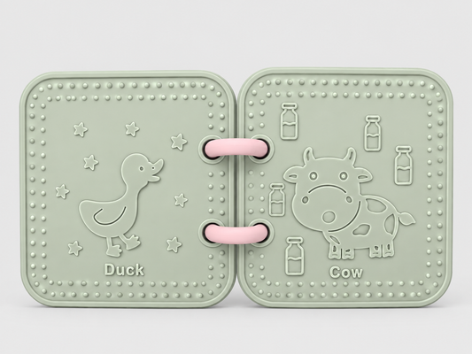 A silicone bath book in sage green , featuring embossed animal designs of a duck and a cow on a light gray background.