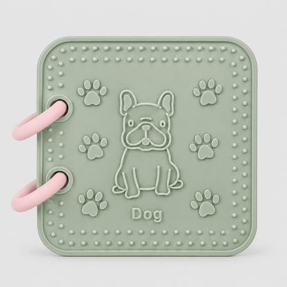 A silicone bath book in sage green featuring front page dog toy. Features an embossed French Bulldog, paw prints, and the word 'Dog' in the center, all in a matching sage green color.