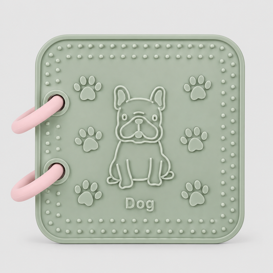 A silicone bath book in sage green featuring front page dog toy. Features an embossed French Bulldog, paw prints, and the word 'Dog' in the center, all in a matching sage green color.