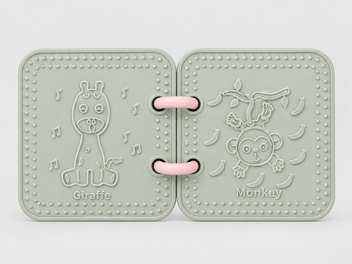 A silicone bath book in sage green, featuring embossed animal designs including a giraffe and a monkey on a branch with bananas.