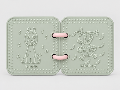 A silicone bath book in sage green, featuring embossed animal designs including a giraffe and a monkey on a branch with bananas.