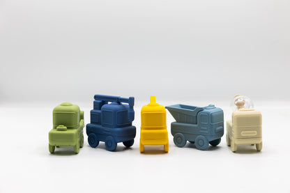 Construction bath toy trucks set in green, blue, yellow, and beige arranged in a row