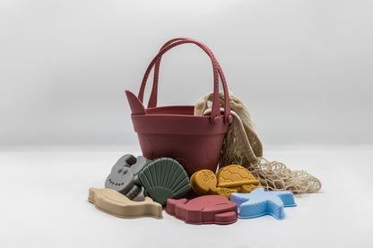Sand moulding beach set with maroon bucket, sea molds, and beige mesh sand bag