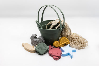 Sand moulding beach set with dark green bucket, sea molds, and beige mesh sand bag