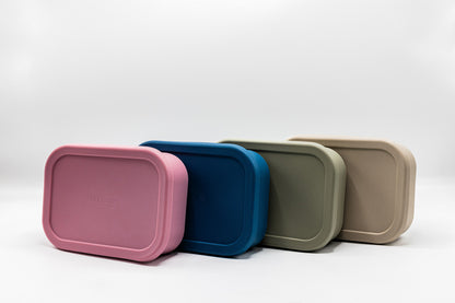 Stacked bento boxes with pink, blue, olive and beige lids in a compact set