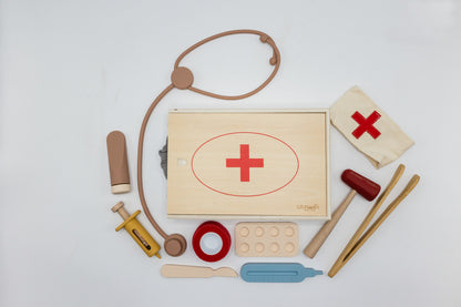 Wooden doctor play set with stethoscope, bandage, syringe pieces, and red-cross pouch
