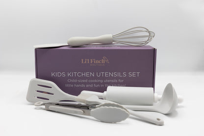 Kids kitchen utensil set with white whisk and spatulas resting in open box