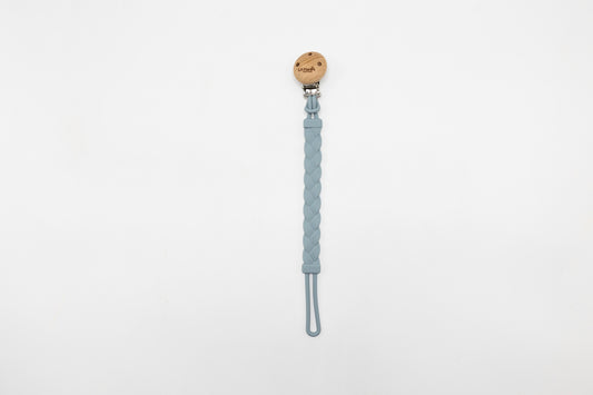Blue dummy clip with braided strap and round wooden logo tag