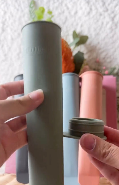 Popsicle mold tube close-up held by hands, dark gray and pink