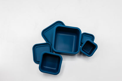 Navy blue silicone snack box set with three square trays and a small cup