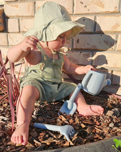 Kids watering can and rake/spade toy set with light blue pieces; child in green overalls